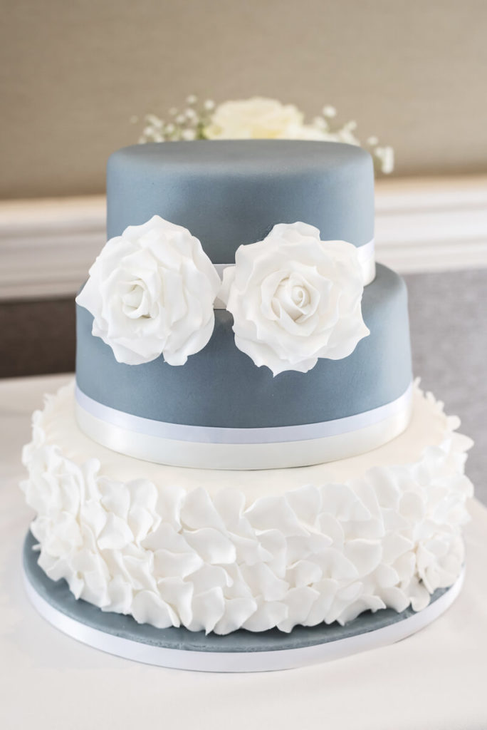 Hochzeitstorte in Blau mit weißen Rüschen