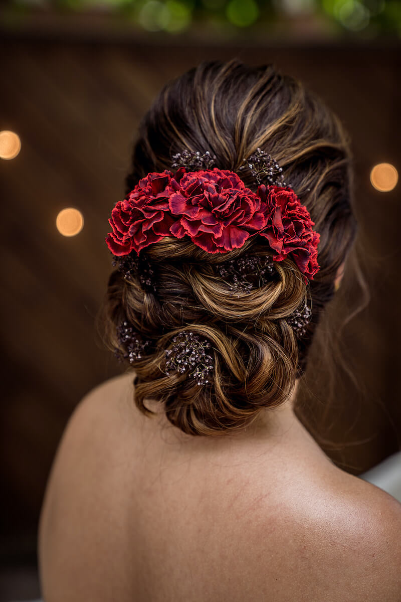 Brautfrisur hochgesteckt mit roten Haarblumen