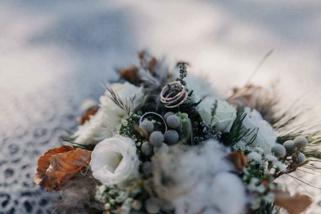 Hochzeit in den Bergen: winterlicher Brautstrauß mit Eheringen