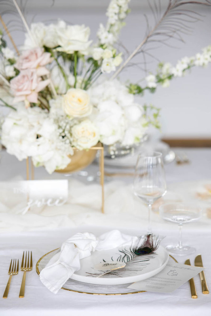 Vornehme Hochzeitsdeko in Gold, Weiß und mit Pfauenfedern